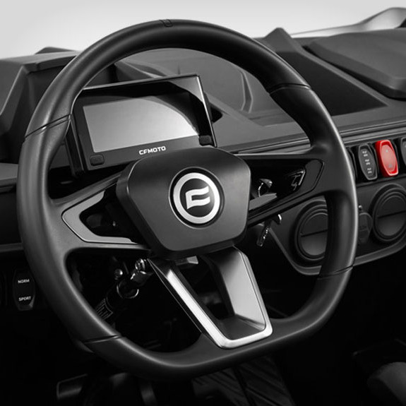 Close-up of a zforce 950 sport steering wheel with a digital display behind it and various control buttons on the dashboard.