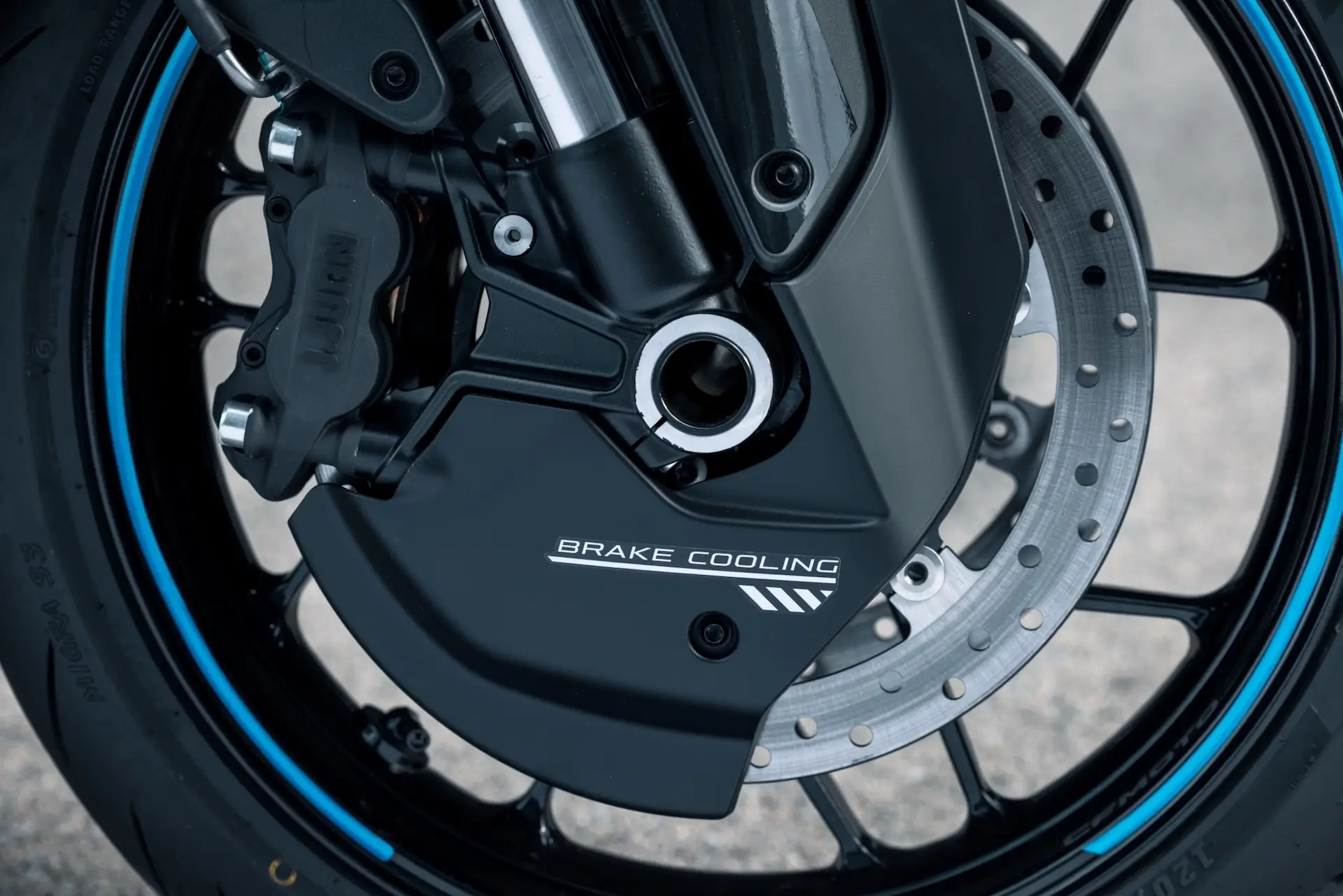 Close-up of a 125NK motorcycle front wheel showing the brake disc, brake caliper, and a cover labeled "Brake Cooling.