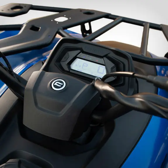 Close-up of a digital display dashboard and handlebars on a blue CForce 450 all-terrain vehicle (ATV), with a cargo rack visible in the background.