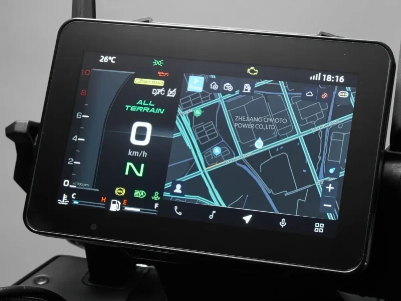 A close-up of a digital motorcycle dashboard, featuring the CFMOTO T-Box, displaying speed, gear, temperature, and a navigation map with nearby locations.