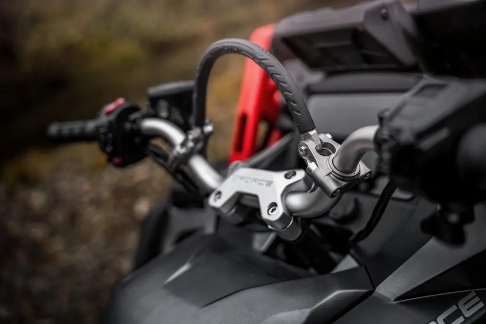 Close-up of the UFORCE U10 XL PRO's handlebars and steering apparatus, showing the grips, controls, and part of the dashboard.
