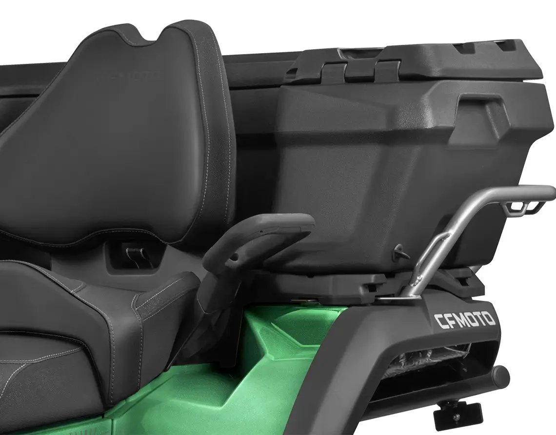 Close-up of a black and green ATV seat on the CForce 1000 Touring Premium, featuring a rear storage compartment and a sturdy metallic handle.