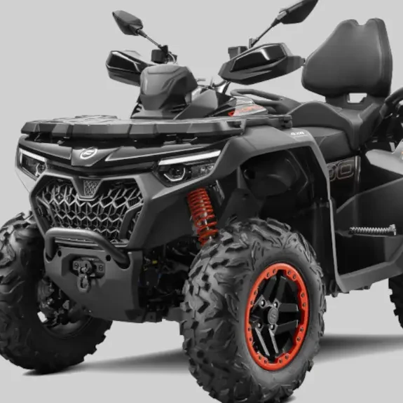 CFORCE 1000 TOURING PREMIUM SHOCKS The CForce 1000 Touring Premium flaunts its black and gray design with striking orange accents. This powerful ATV, equipped with large off-road tires and a robust front grille, stands proudly against a muted light gray backdrop.