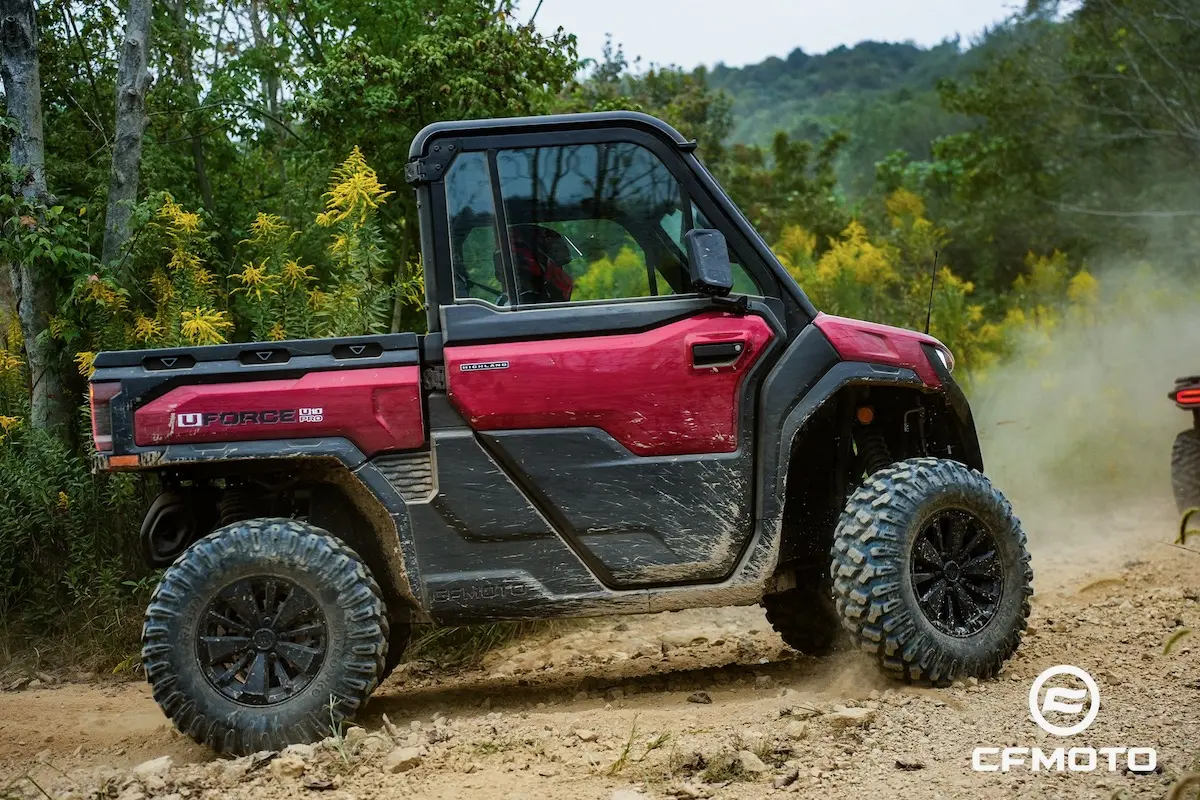 A red CFMOTO UFORCE 1000 utility vehicle drives on a dirt trail surrounded by vegetation and trees, highlighting the thrill of outdoor adventure and the importance of ATV safety.
