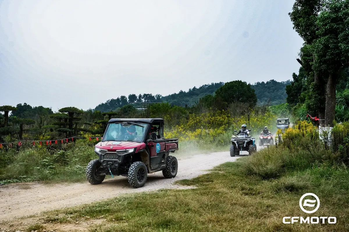 Several off-road vehicles drive along a dirt path surrounded by greenery, highlighting the importance of ATV safety, with the CFMOTO logo visible in the bottom right corner.