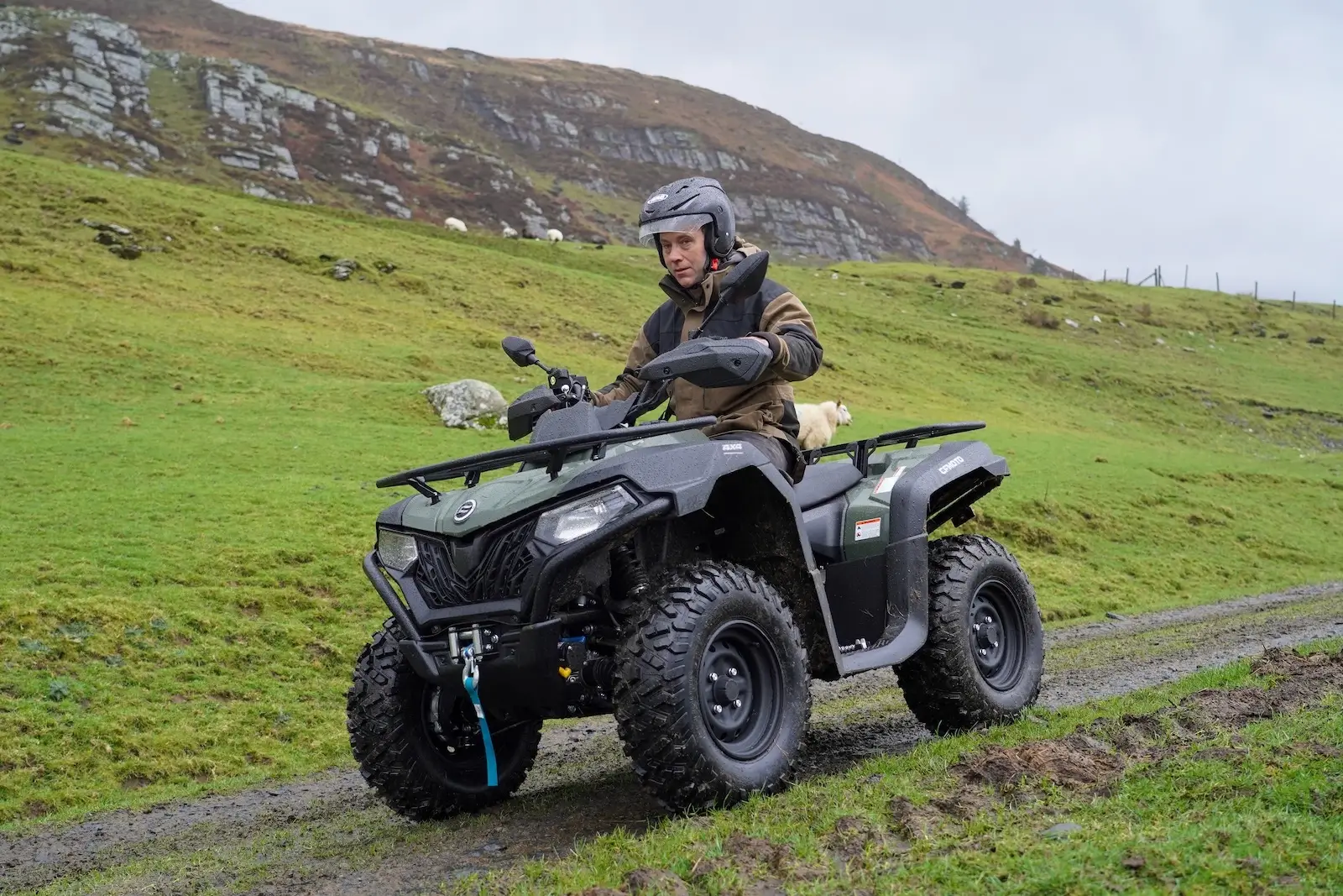 Riding an ATV on a grassy trail with hills in the background is exhilarating. To enhance your adventure, remember essential tips on how to ride your quad safely, ensuring both fun and safety on every twist and turn of the rugged path.