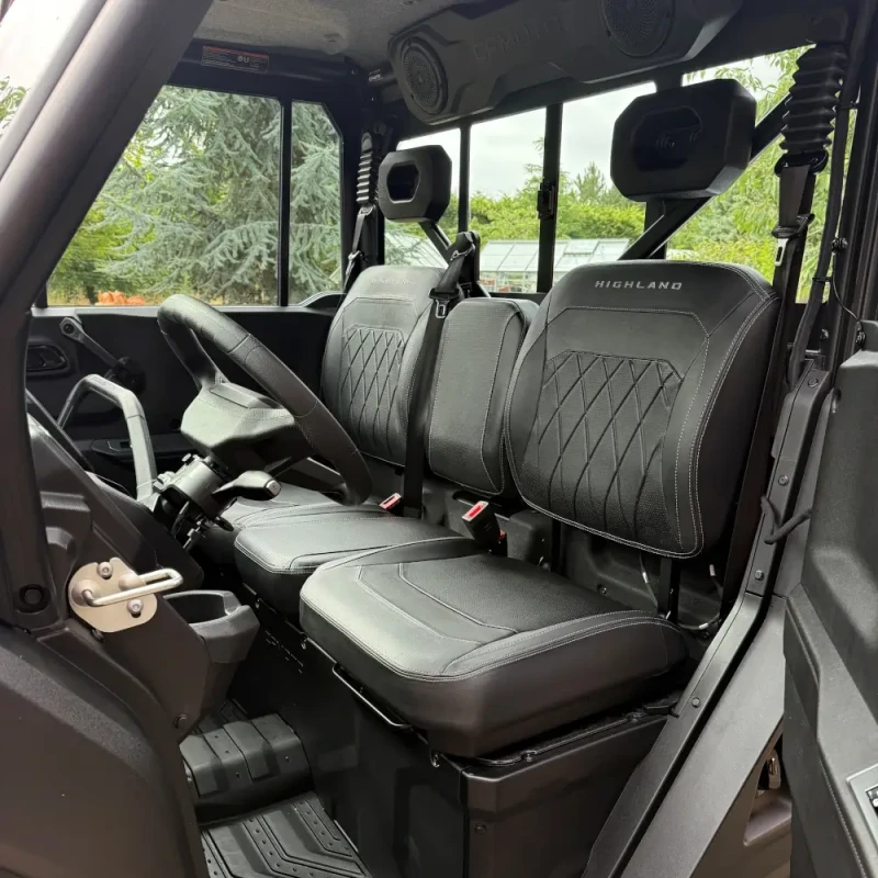 Two black leather front seats with "HIGHLAND" branding inside the UFORCE U10 PRO, showing the steering wheel, dashboard, and seat belts.