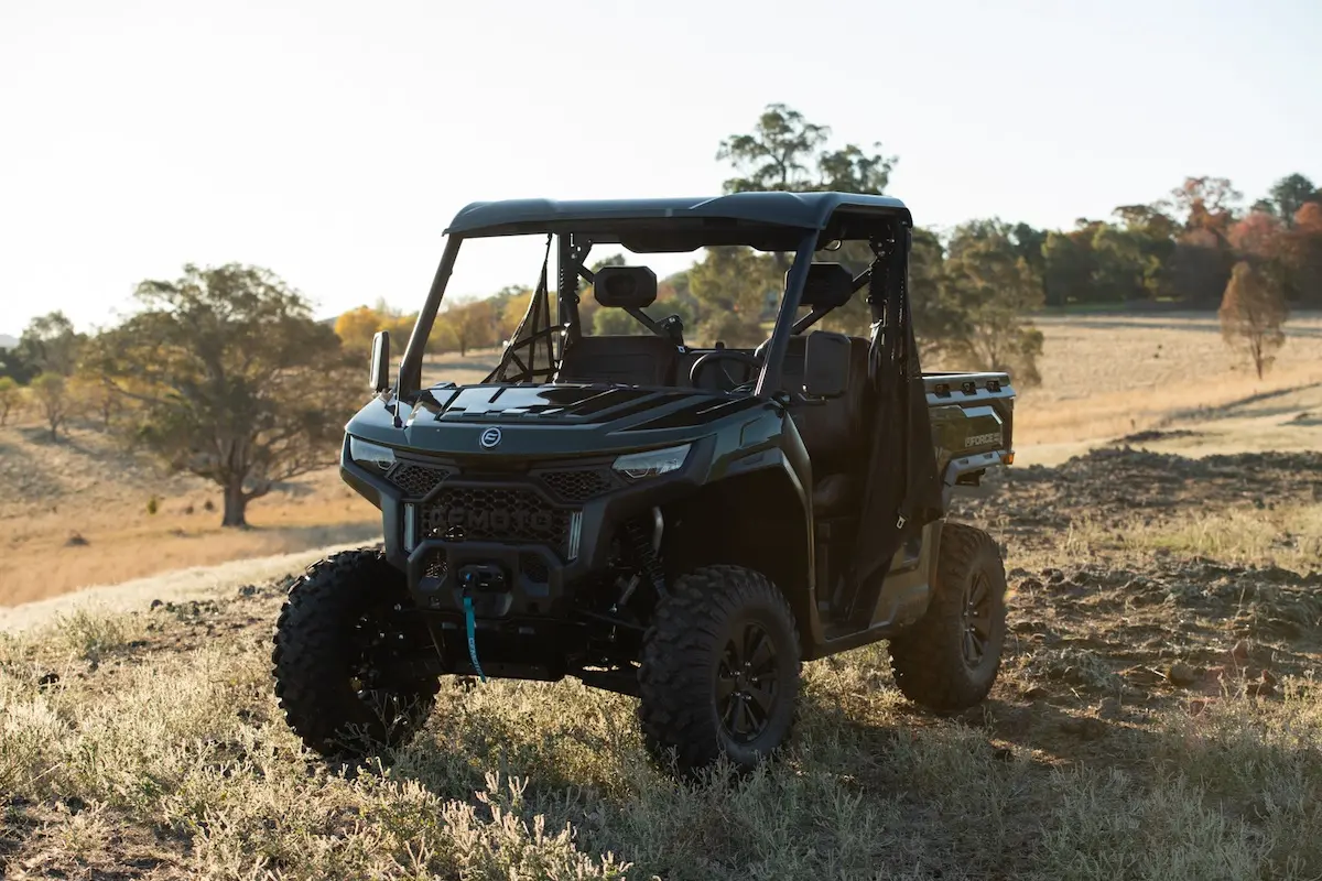 The black UFORCE U10 PRO AGRI utility terrain vehicle (UTV) is parked on dry, grassy terrain with trees and a clear sky in the background.
