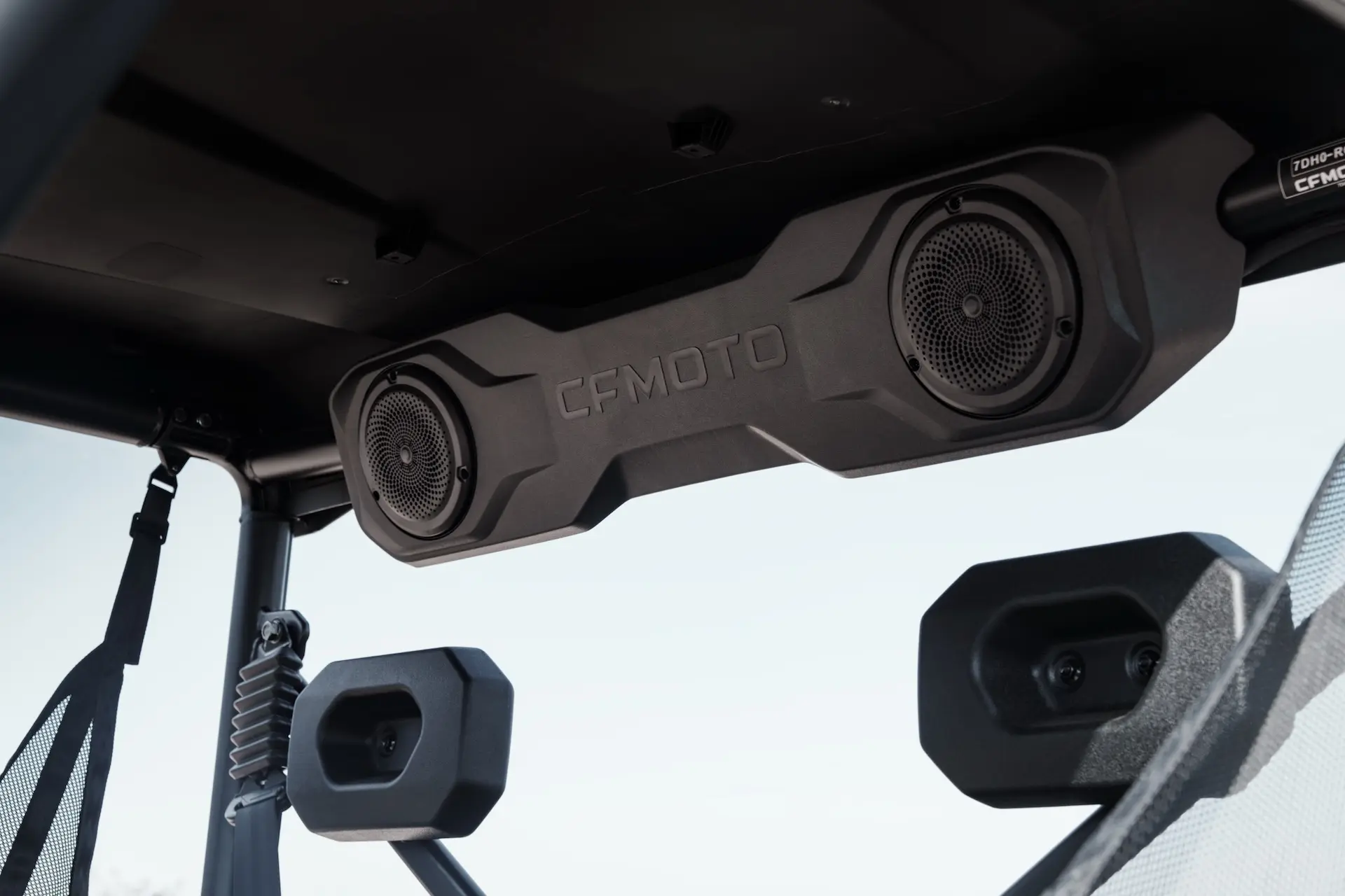Close-up of a CFMOTO soundbar with two speakers mounted on the interior roof of a UFORCE 600 vehicle.