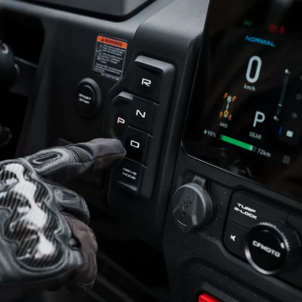 A gloved hand presses the "P" button on the UFORCE EVU6 Commercial's electronic gear selector next to a digital dashboard display.