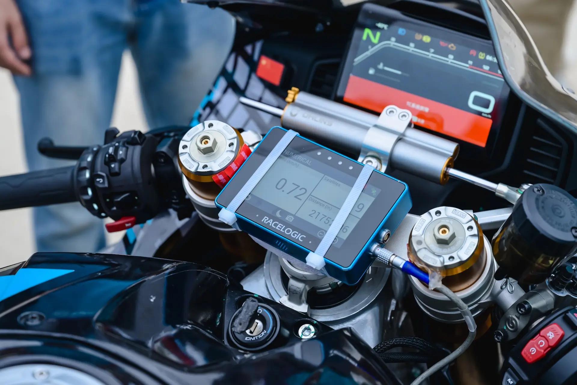 Close-up of a CFMOTO V4 SR-RR dashboard displaying digital speed, control buttons, and a Racelogic performance monitor capturing a top speed of 315.82 km/h.